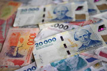 This illustration picture shows Argentine pesos bills in Buenos Aires, on July 14, 2025. (Photo by Luis ROBAYO / AFP)